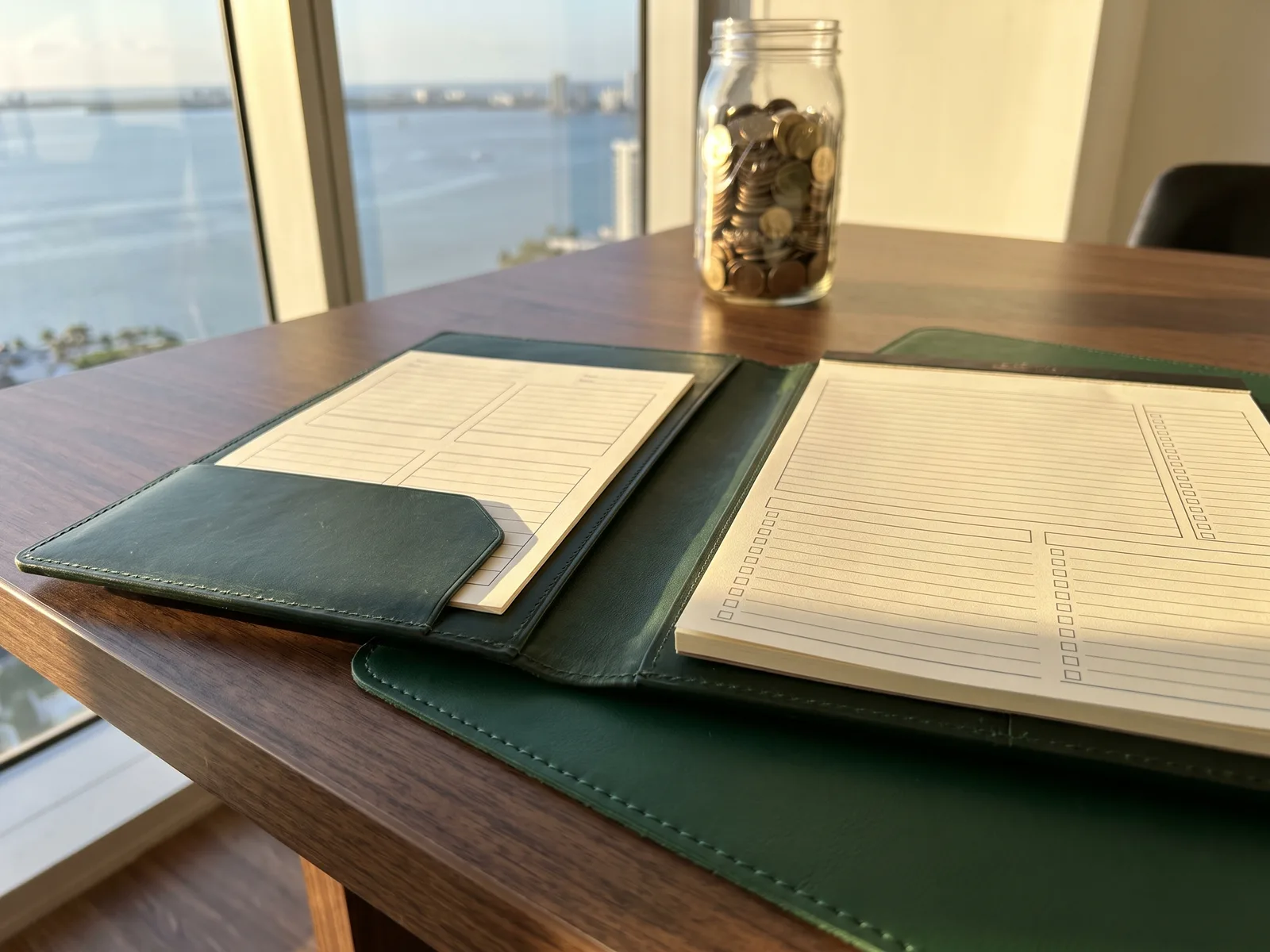 Leather portfolio with retirement plan documents and a jar of gold coins